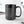 Black mug with text on a white surface with blurred background. Funny office mug.