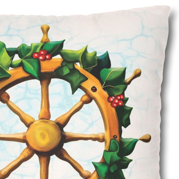 Decorative pillow with a ship's wheel and holly design on a white background