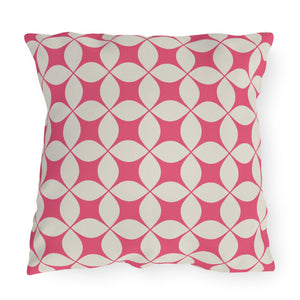 A square-shaped outdoor throw pillow with a pink and ivory geometric pattern.