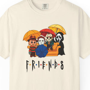 Beige t-shirt with 'Friends' graphic featuring horror movie characters with umbrellas on a white background