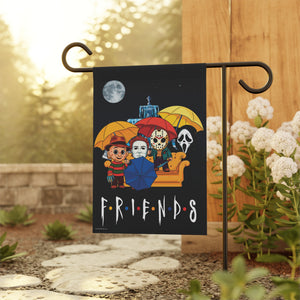 A decorative garden flag featuring the Friends horror characters under colorful umbrellas on a black background, displayed on a black metal stand in a garden setting.