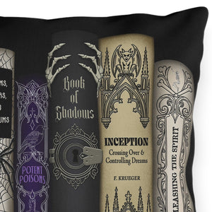 A square black throw pillow featuring a printed graphic of six gothic-style book spines, including titles such as The Glass Cauldron, The Graveyard Diaries, Venom, Cloaks, and Astronomica, Book of Shadows, Inception, and The Spirit.