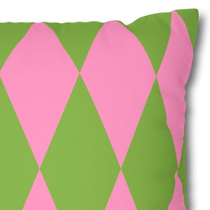 Decorative pillow with pink and green diamond pattern on a white background