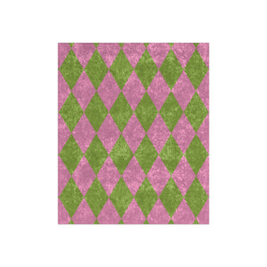 Pink and green diamond patterned throw blanket on a white background