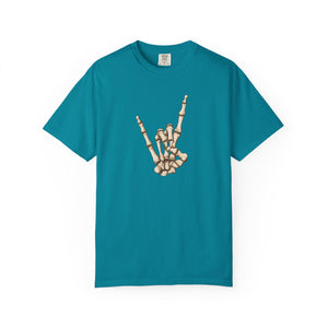 A teal short-sleeve crewneck t-shirt featuring a graphic of a skeletal hand making the rock on gesture on the chest, displayed against a solid white background.