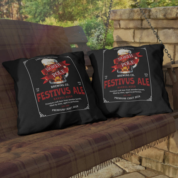 Two black pillows with 'Festivus Ale' design on a wooden bench outdoors.