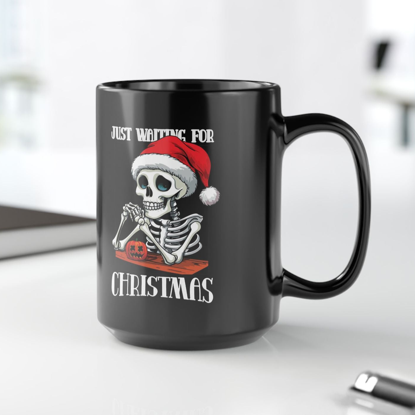 Black mug with a skeleton wearing a Santa hat and text 'Just Waiting for Christmas' on a white background