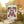 Decorative garden flag with 'Mama Claus Moonshine Distillery' design on a stand outdoors.