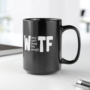 Black mug with 'WTF' text on a white surface with office items in the background