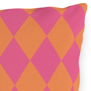 Pink and orange diamond patterned pillow on a white background