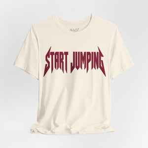 An off-white short-sleeve t-shirt with a dark red stylized metal-style graphic reading 'START JUMPING' across the chest, displayed on a light gray gradient background.