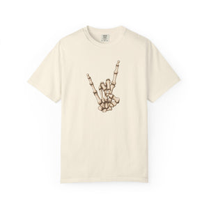 An off-white short-sleeve crewneck t-shirt featuring a graphic of a skeleton hand making the rock on gesture on the chest, displayed against a clean white background.