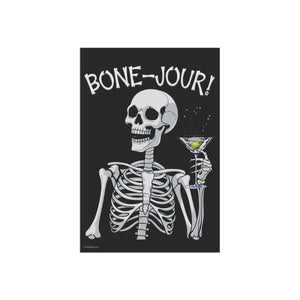 Yard flag and banner with a skeleton holding a martini that says Bone-jour at the top on a black background.