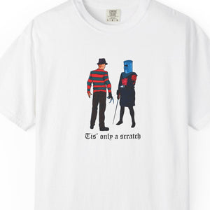 White t-shirt with graphic design of two characters and text 'Tis' only a scratch on a white background