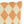 Decorative pillow with orange and beige diamond pattern on a white background