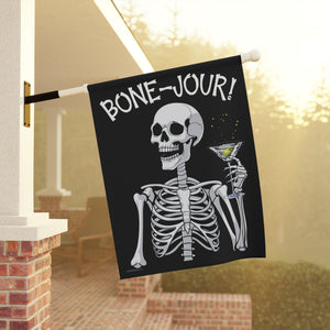 Yard flag and banner with a skeleton holding a martini that says Bone-jour at the top on a black background.