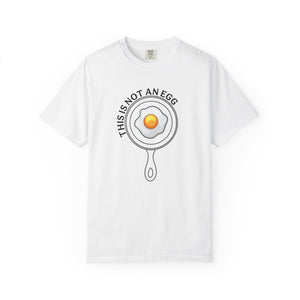 White t-shirt with 'This is not an egg' and an egg in a frying pan on a white background
