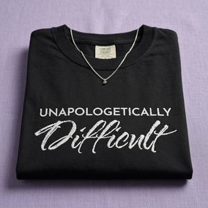 Black sweatshirt with 'Unapologetically Difficult' text on a purple background