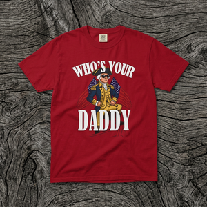 Red t-shirt with graphic design and text on a wooden surface