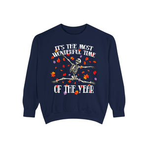 A navy blue crewneck sweatshirt featuring a Halloween graphic of a skeleton jumping over crossed hockey sticks, surrounded by falling autumn leaves, with the text 'IT'S THE MOST WONDERFUL TIME OF THE YEAR'.