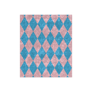 Harlequin patterned throw blanket with blue and pink diamonds on a white background