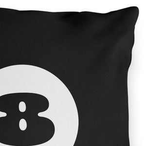A black outdoor throw pillow with a white 8 ball design in the center.