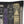 A square black throw pillow featuring a printed graphic of book spines in a gothic style, including titles like 'The Glass Cauldron', 'Venoms, Elixirs, and Nootrums', 'Book of Shadows', and 'Inception'.