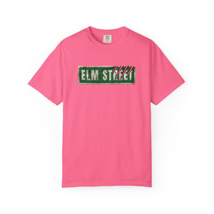 A bright pink short-sleeve t-shirt with a distressed green 'ELM STREET' sign graphic printed across the chest, displayed on a clean white background.