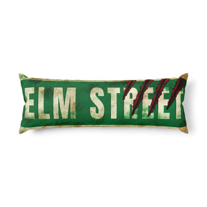 A rectangular throw pillow designed to look like a vintage green Elm Street street sign, featuring distressed white lettering and red claw marks, shown on a plain white background.
