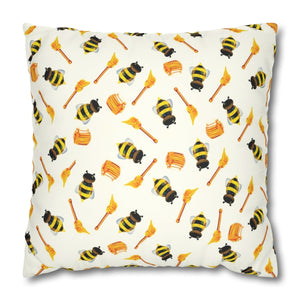A square-shaped pillow cover with a pattern of honey bees and floral elements in yellow, black, and white colors on a faux suede material.