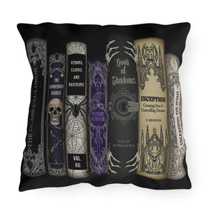 A square black throw pillow featuring a printed graphic of six gothic-style book spines with horror-themed titles and illustrations, shown against a plain white background.