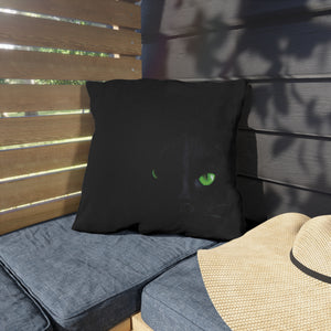 Plaid pillow on a cushioned bench with a straw hat nearby, against a wooden slat wall.
