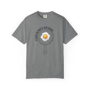 Gray t-shirt with an egg in a pan graphic and 'this is not an egg' text on a white background