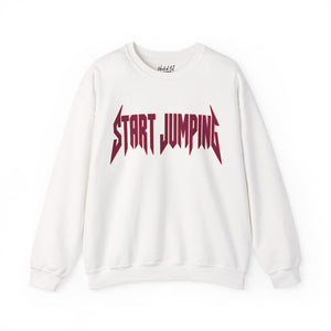 An off-white crewneck sweatshirt featuring the words 'START JUMPING' printed across the chest in a stylized dark red font, displayed on a clean white background.
