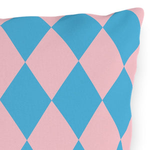 Decorative pillow with blue and pink diamond pattern on a white background