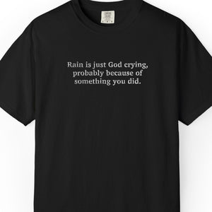 Black t-shirt with 'Rain is just God crying, probably because of something  you did." embroidered text on a white background