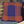 Blue pillow with orange lines on a gray cushion next to a straw hat against a wooden and dark panel background.