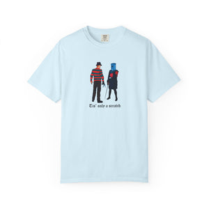 Light blue t-shirt with graphic design of two characters and text 'Tis' only a scratch on a white background