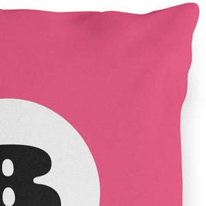 A square-shaped outdoor throw pillow with a pink background and a black and white 8 ball in the center.