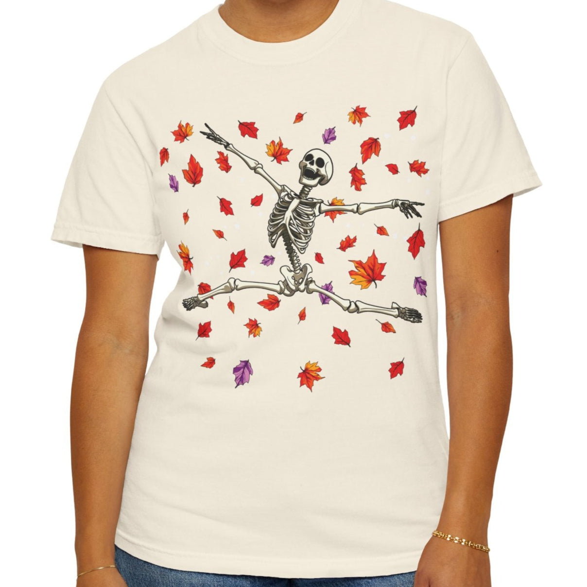 Person wearing a white t-shirt with a skeleton and leaf design on a white background