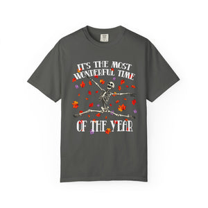 Grey t-shirt featuring a Halloween graphic of a dancing skeleton surrounded by falling red and purple leaves, with the text 'IT'S THE MOST WONDERFUL TIME OF THE YEAR'.