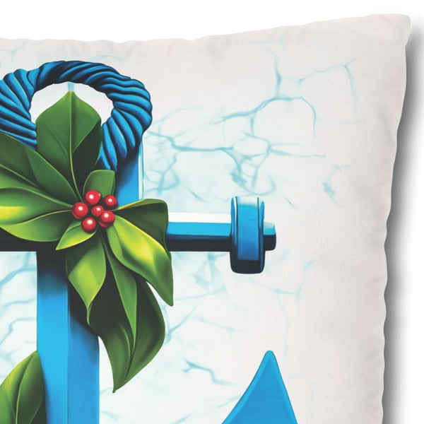 Decorative pillow with a blue anchor design featuring green leaves and red berries on a white background.