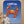 Baby sitting on a blue blanket with a cartoon crab and personalized text on a wooden floor.