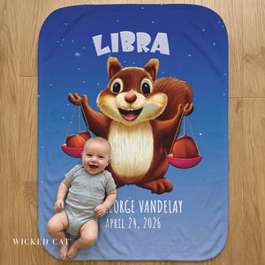 Baby with cartoon squirrel holding scales on a 'Libra' themed blanket