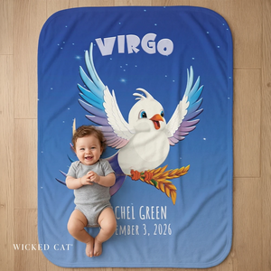 Baby on a blue blanket with a cartoon dove and 'Virgo' text, sitting on a wooden floor.