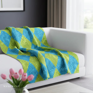 blue and green harlequin throw over a white sofa