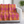 Patterned pink and orange blanket draped over a white sofa in a room with a plant.