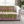 Patterned pink and green blanket on a white sofa in a living room setting.