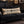 Decorative body pillow that reads Bates Motel Bed & Breakfast on a black sofa Halloween decor.