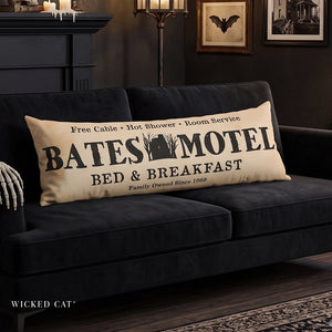Decorative body pillow that reads Bates Motel Bed & Breakfast on a black sofa Halloween decor.